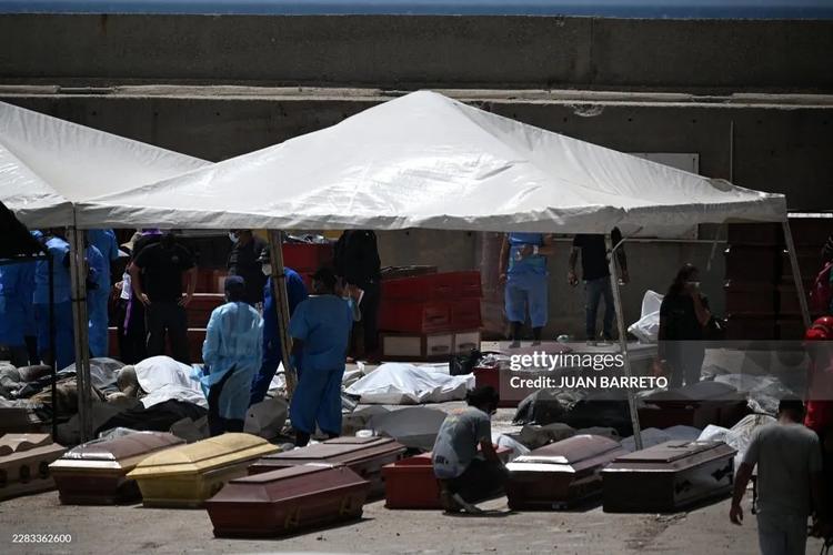Forensic experts stand amid victims and coffins in La Guaira, La Guaira State, Venezuela on June 29, 2026, following the June 24 twin earthquakes. 