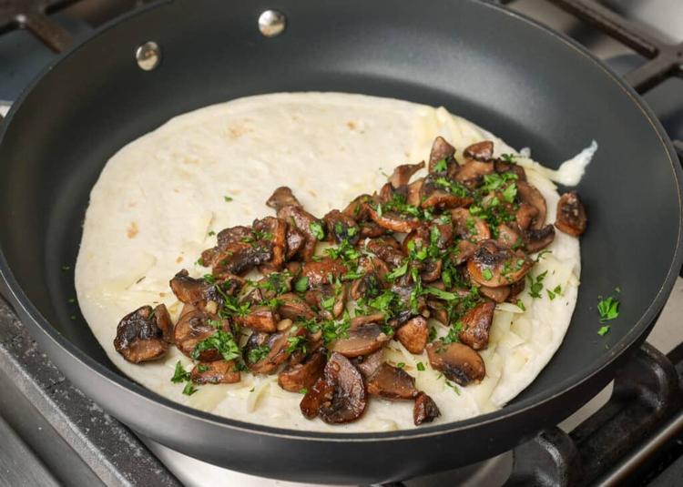 mushrooms on tortilla in skillet