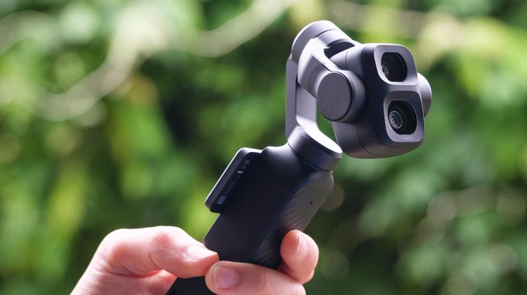 The DJI Osmo Pocket 4P in a person's hand with its head angled.