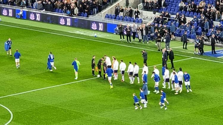 Everton and Newcastle United players shaking hands on the pitch ahead of kickoff in the Carabao Cup