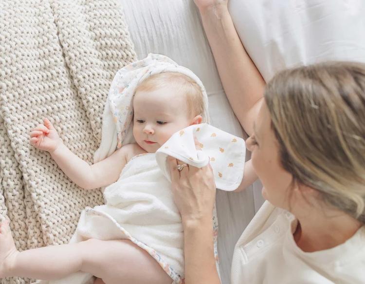 Mom gently cleaning her baby with a soft KeaBabies Cami Baby Washcloth.
