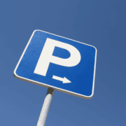 A blue parking sign with a white “P” and a right-pointing arrow, photographed against a clear blue sky, marks convenient access to the Ann and Roy Butler Trail—a favorite in every runner’s guide and one of Austin’s most scenic hike-and-bike trails. Austin Marathon Half Marathon & 5K
