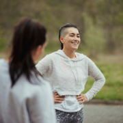 Smiling person with hands on hips outdoors