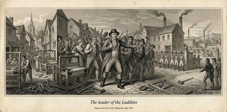 An 1812 engraving, “The Leader of the Luddites,” showing a crowd of textile workers during a frame-breaking protest, their leader holding a hammer, a cotton mill and soldiers in the background and broken machinery at their feet.