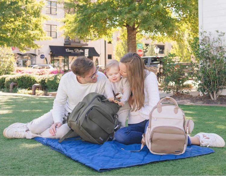 Mom and dad having fun together at the park during a family outing.