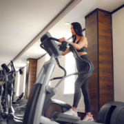 Woman exercising on elliptical machine in gym