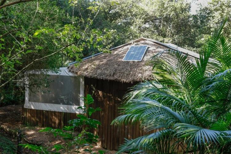 Foto colorida que mostra placa do sistema fotovoltaico instalado em viveiro da Teko’a Anhetenguá, na Lomba do Pinheiro, em Porto Alegre
