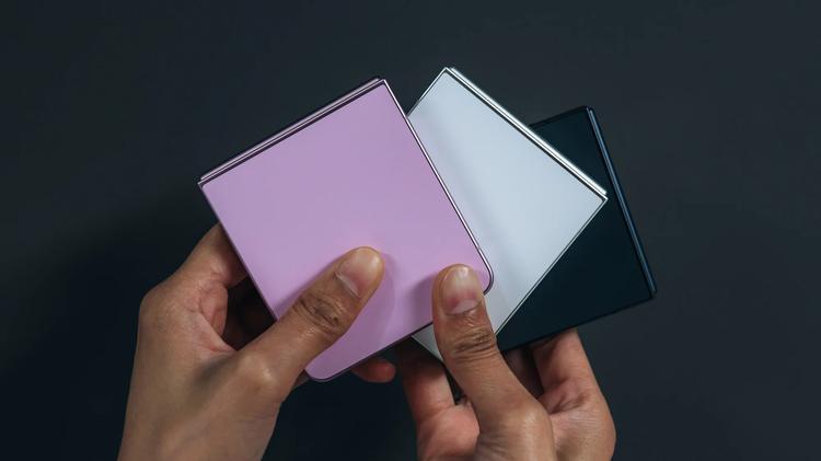 person holding pink and white galaxy z flip 8 phones in hand