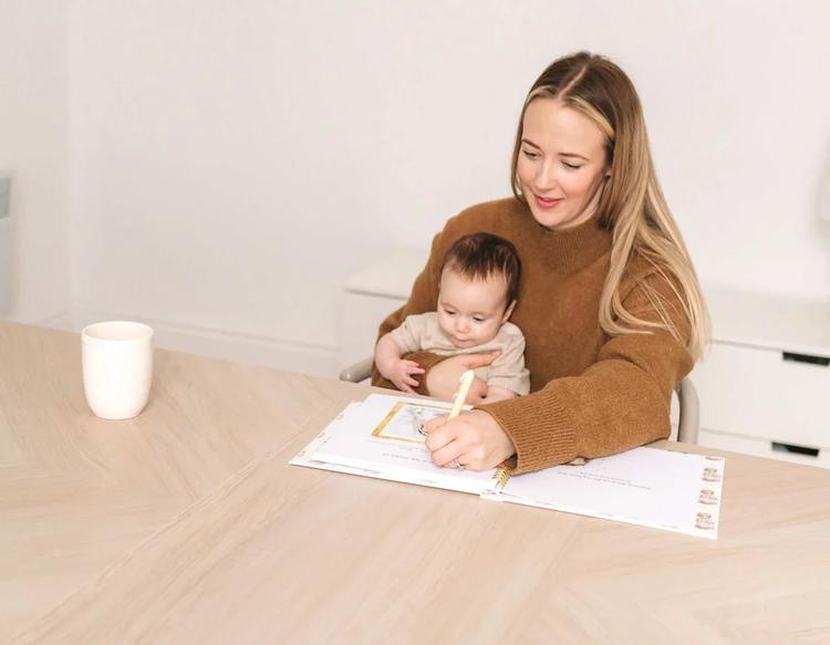 A mom taking detailed notes about her baby to track growth and developmental milestones.