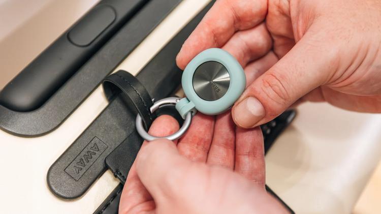 person holding galaxy smart tag 2 in keychain