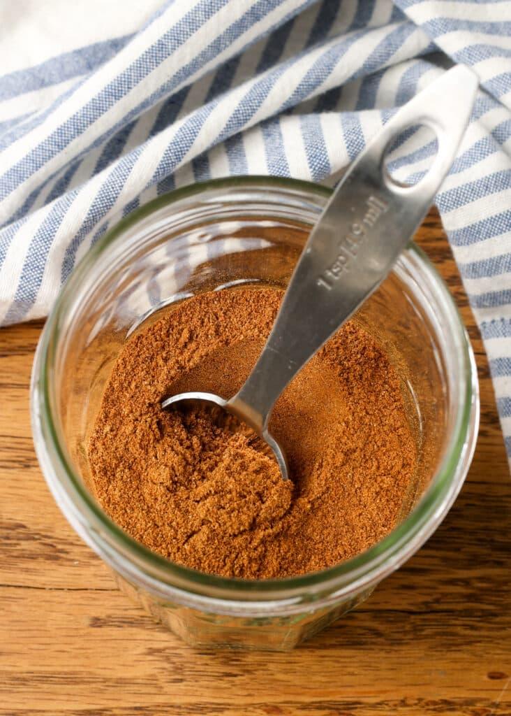 pumpkin pie spices in jar with measuring spoon