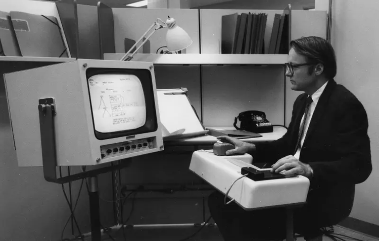Douglas Engelbart’s demonstrating an early desktop computer set up during his 1968 “Mother of All Demos”