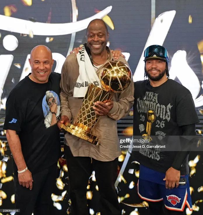 Assistant Coach Rick Brunson, Jamaican-born Patrick Ewing, Jamaican roots Jalen Brunson #11 of the New York Knicks, pose for a photo with the Larry O'Brien Championship Trophy during Game Five of the 2026 NBA Finals on June 13, 2026, at Frost Bank Center in San Antonio, Texas. (