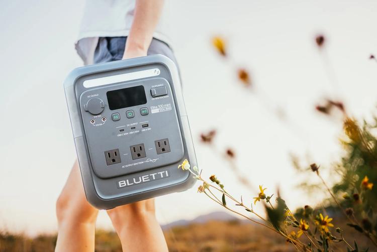 a person carries the Bluetti Elite 100 mini portable power station