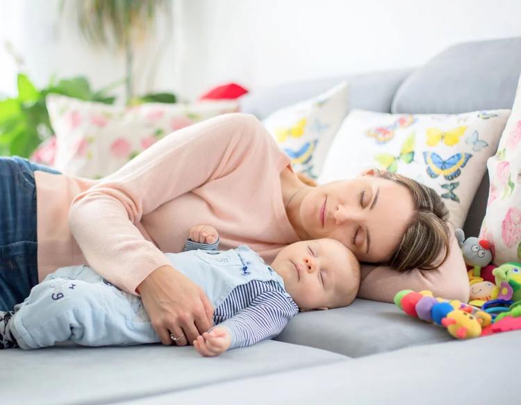 Mom and baby sleeping peacefully after a full day, resting together in a calm and comforting home environment.