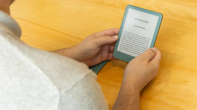 over the shoulder view of man holding kindle e-reader