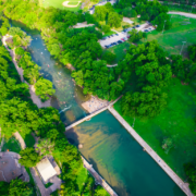 Aerial view of park with river and bridge