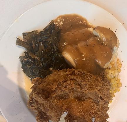 Classic fried chicken breast served with collard greens, mashed potatoes, creamed corn, cracked pepper and sausage herb gravy at Magnolias Restaurant.