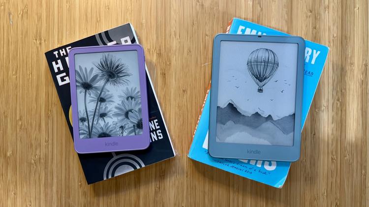 A Kindle and a Kindle Paperwhite Signature Edition on top of two books