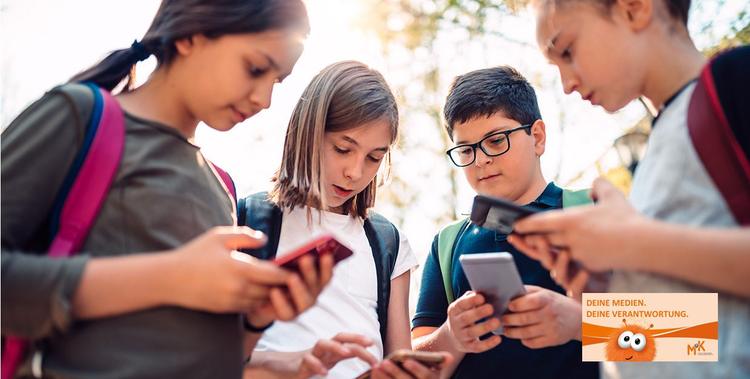  Kinder schauen in ihr Smartphone