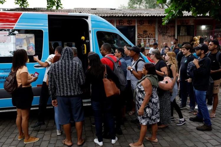 Fila para embarcar em van no Rio: deslocamentos longos, custos altos, insegurança e exclusão revelam como o racismo estrutural impacta no direito de ir e vir (Foto: Fernando Frazão / Agência Brasil - 28/10/2025)