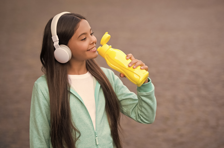 girl drinking water from yellow eco-friendly bottle