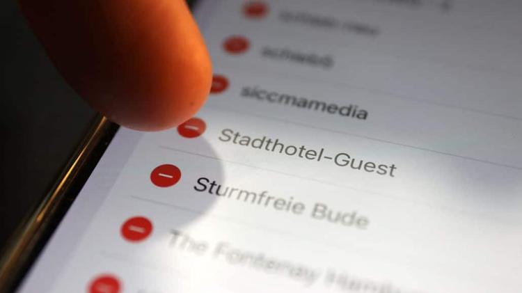 Finger wählt WLAN-Netzwerk auf Smartphone-Bildschirm