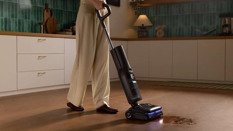 The Roborock F25 Ultra wet and dry vacuum cleaner cleaning up a wet spill in a kitchen.