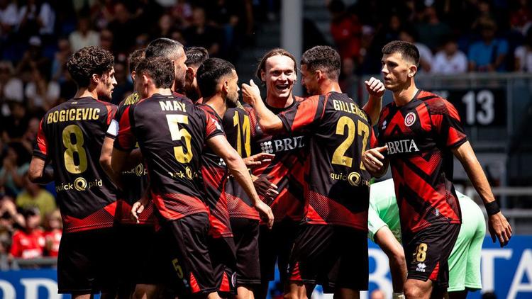  Fußball auf dem Rasen der von zwei Spielerhänden festgehalten wird