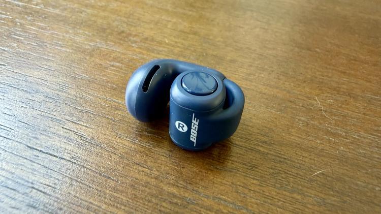 close up of blue bose ultra open earbud on table