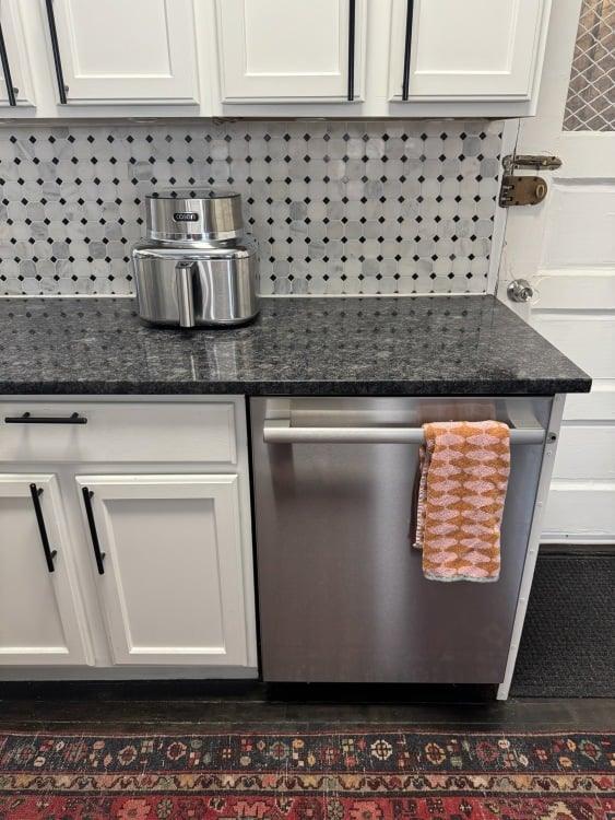 a cosori iconic air fryer on a kitchen countertop near a bosch dishwasher