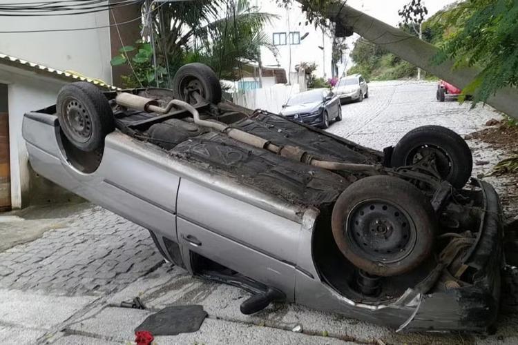 Com as rodas para cima: carro capota, derruba poste e deixa dois feridos em Arraial do Cabo