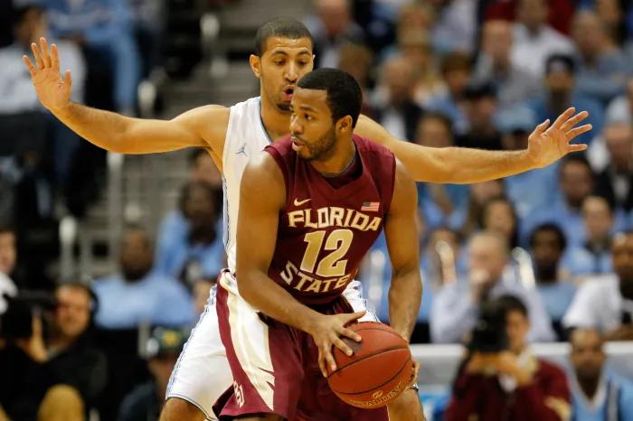 Jeff Peterson of the Florida State Seminoles looks to pass while a defender guards him.