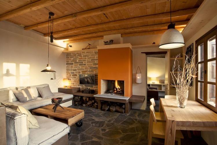 In the living room of Villa Thalia in Pelion there is a corner sofa and fireplace.