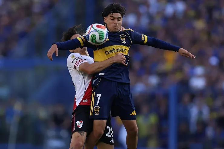 Zeballos salta per contrastare il pallone durante una partita di calcio, indossando la maglia blu e gialla