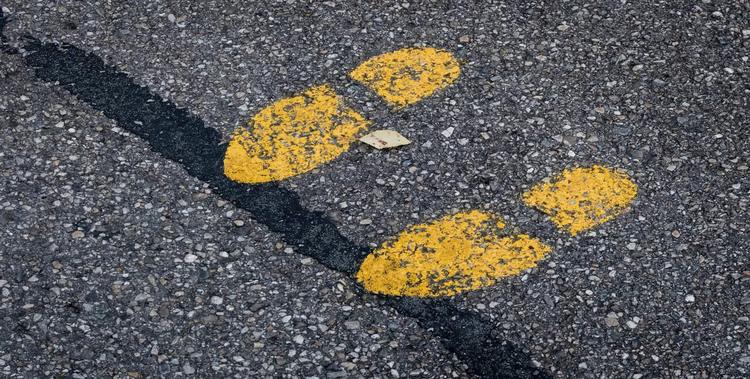  gelber Fußabdruck auf Asphalt