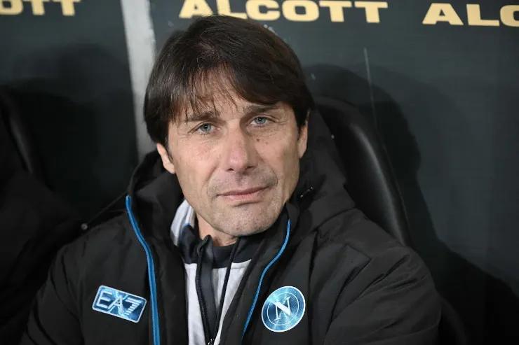 Antonio Conte in panchina durante una partita, con abbigliamento tecnico nero e blu