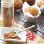 A tiny silver spoon scoops up some Pumpkin Pie Spice Mix from a white serving dish.