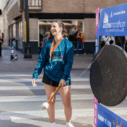 A smiling woman wearing a race medal and 