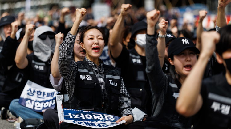 A woman sitting on the ground with a raised fist during a Samsung union rally in Pyeongtaek, South Korea, on Thursday, April 23, 2026.