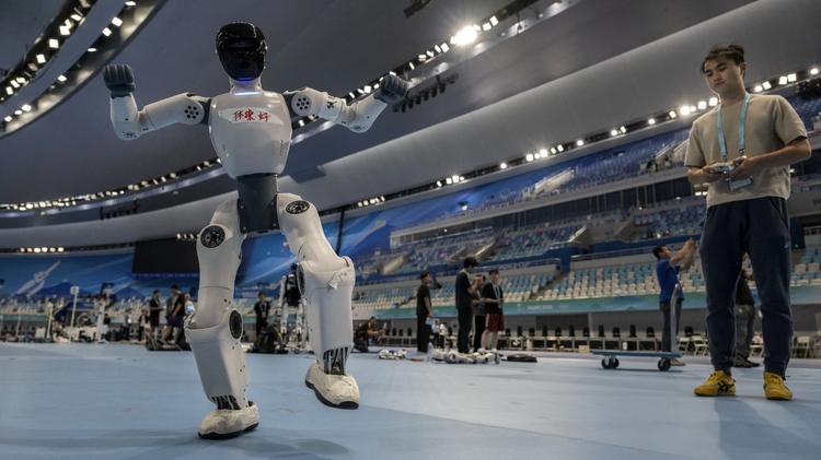 A technician controls a humanoid robot as it dances while training for competition for the 2nd World Robot Games at National Speed Skating Oval on August 18, 2026 in Beijing, China.