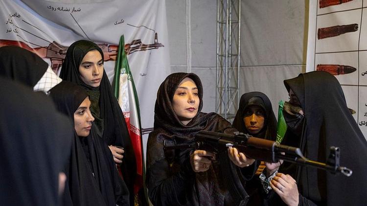 Mujeres aprendiendo a usar un rifle durante una sesión de entrenamiento con armas en una manifestación en Teherán el 23 de mayo de 2026. 