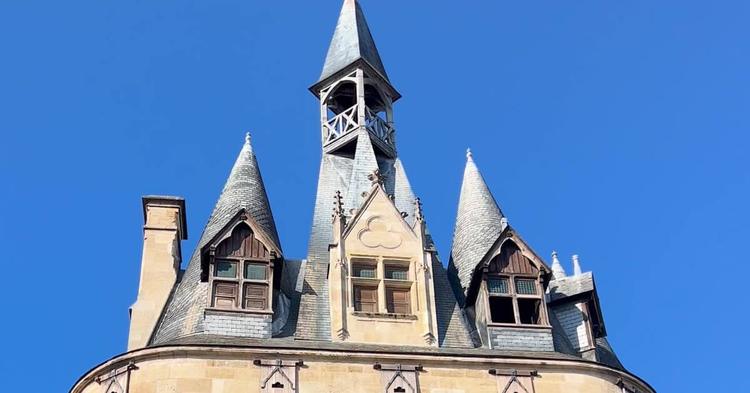 Les tourelles et le clocheton de la porte Cailhau sous un ciel bleu à Bordeaux