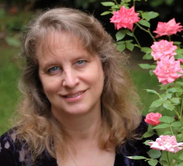 Photo of author Maria Marshall with roses in her garden.