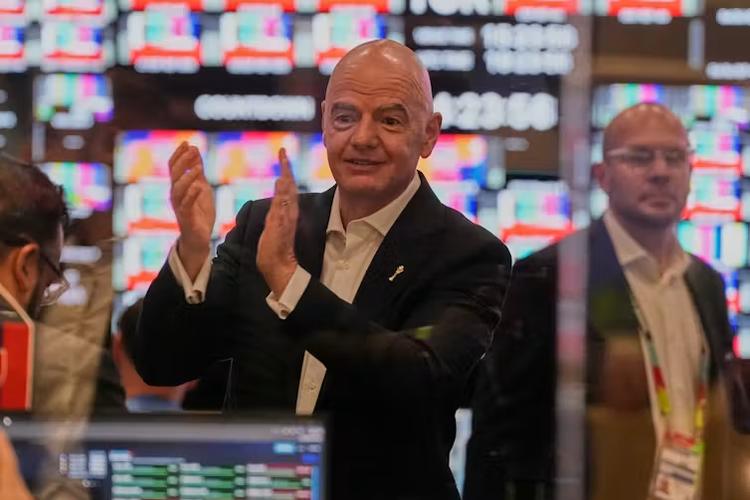 Le président de la FIFA, Gianni Infantino, applaudit, avec des tableaux lumineux en arrière-plan
