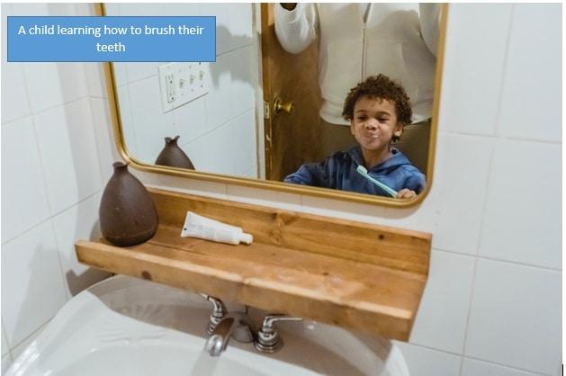 A child learning how to brush their teeth
