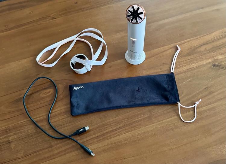 the dyson hushjet mini cool with its accessories on a wooden surface