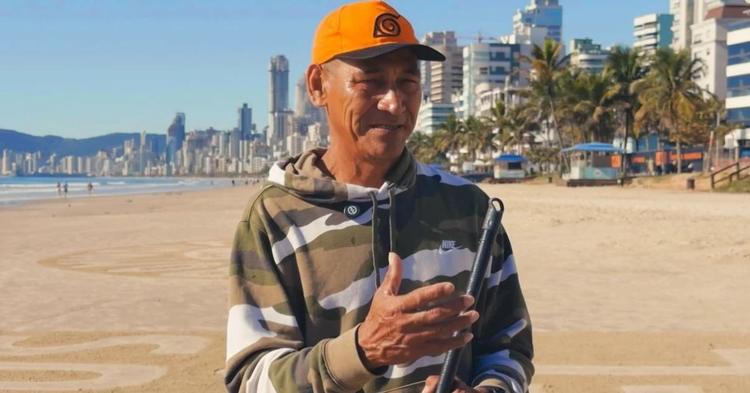 Com um pedaço de madeira, Seu Afonso transforma a praia de Itapema em espaço de fé