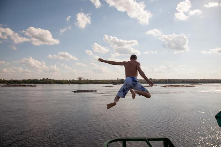 Foto colorida que mostra homem sem camisa pulando no rio. Comunidade Quilombola Forte Príncipe da Beira, na fronteira entre Rondônia e Bolívia (Foto: Avener Prado/ FESTCINEAMAZONIA/2013).