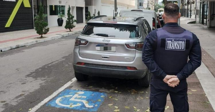 Jeep com mais de R$ 35 mil em dívidas é guinchado após parar em vaga para deficientes em BC
